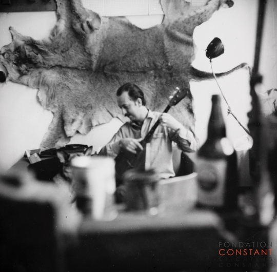 Constant plays guitar in front of lion skin, 1963 Constant plays guitar in front of lion skin, 1963