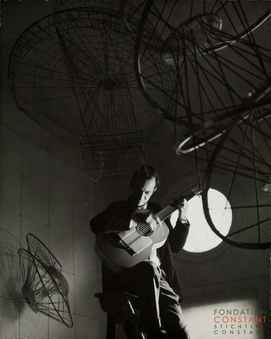 Constant-Constant speelt gitaar op ladder, 1962 Constant Nieuwenhuys-Constant speelt gitaar op ladder, 1962